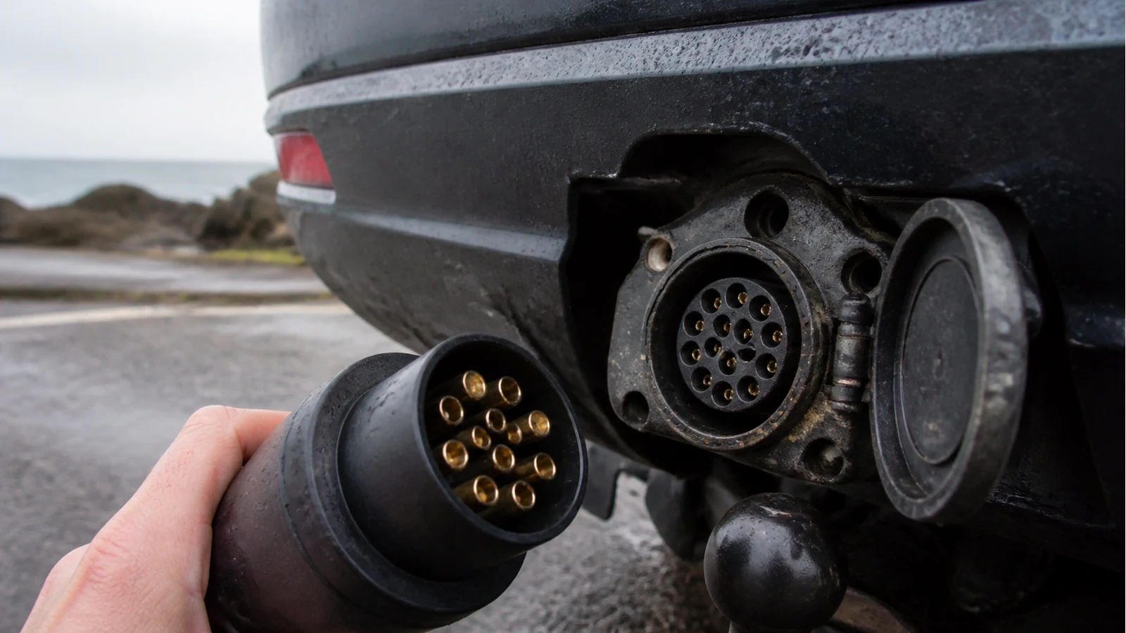Corroded 13-pin tow socket on a UK car next to a clean trailer plug